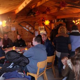 mehrere Personen in einer rustikalen Holzhütte von Brand's Weihnachtsbäume